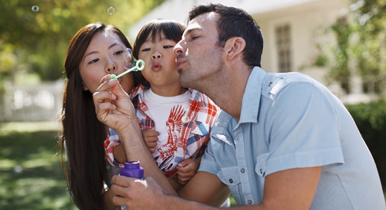 Family blowing bubbles in the garden.