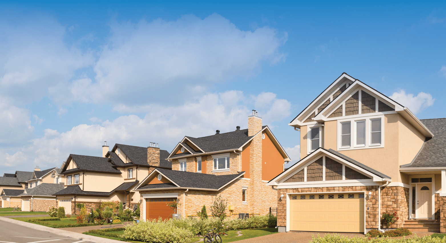 Suburban neighborhood with modern houses and clear blue skies.