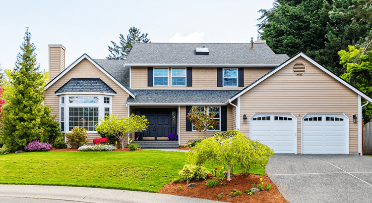 Modern two-story suburban house with a manicured lawn and attached garage.