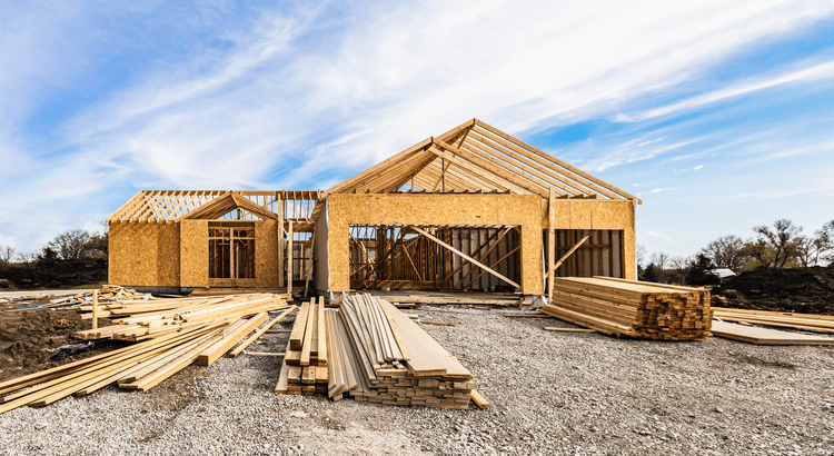 Wooden frame structures under construction on a clear day.