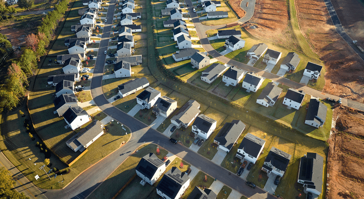 Aerial view of a suburban neighborhood with curved streets and modern houses.