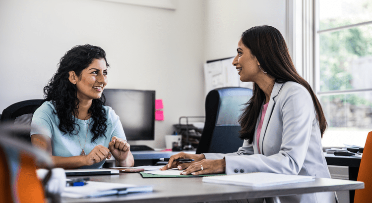 Two women talking in an office.